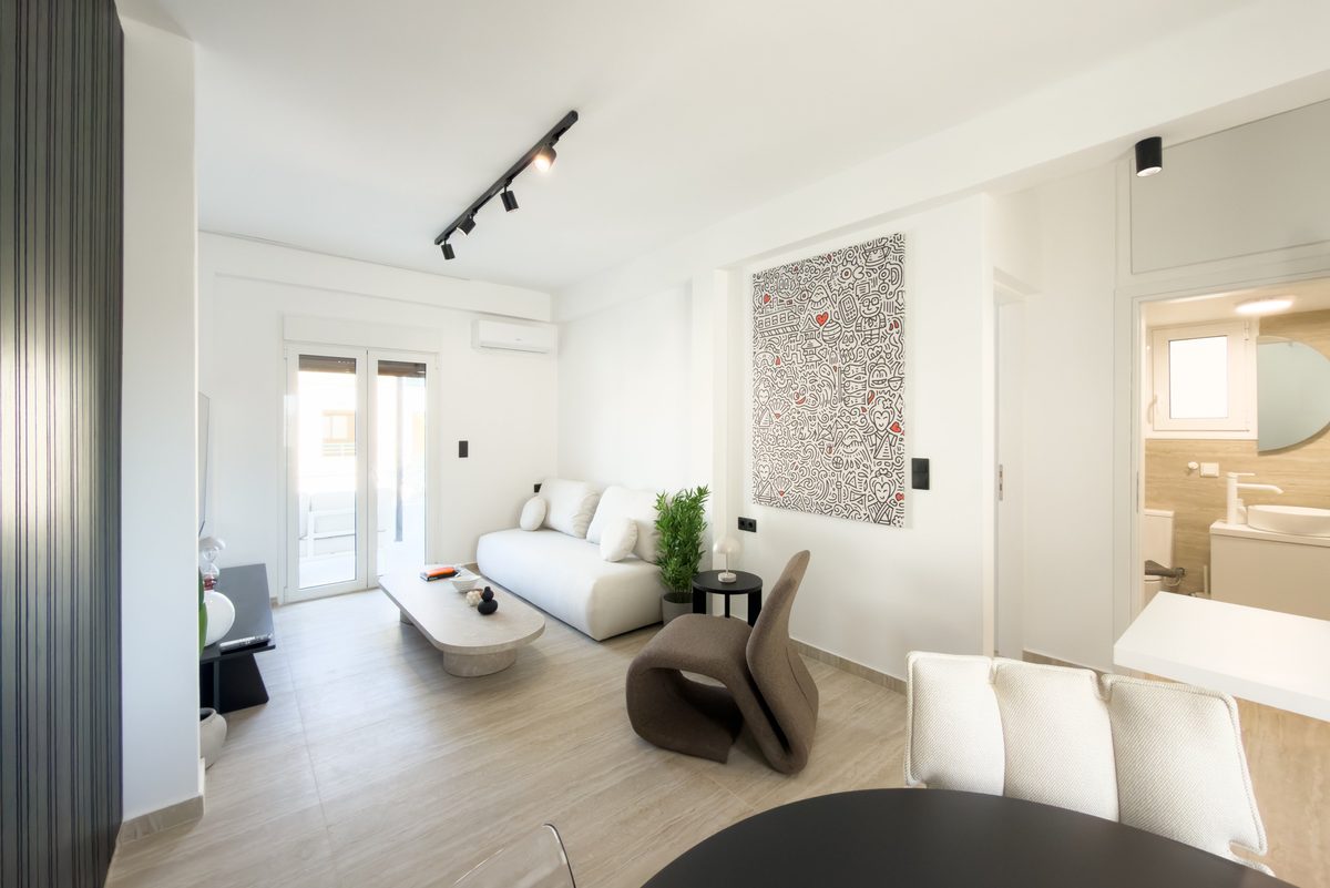 Living room with doodle-art canvas, curved sofa and track lighting