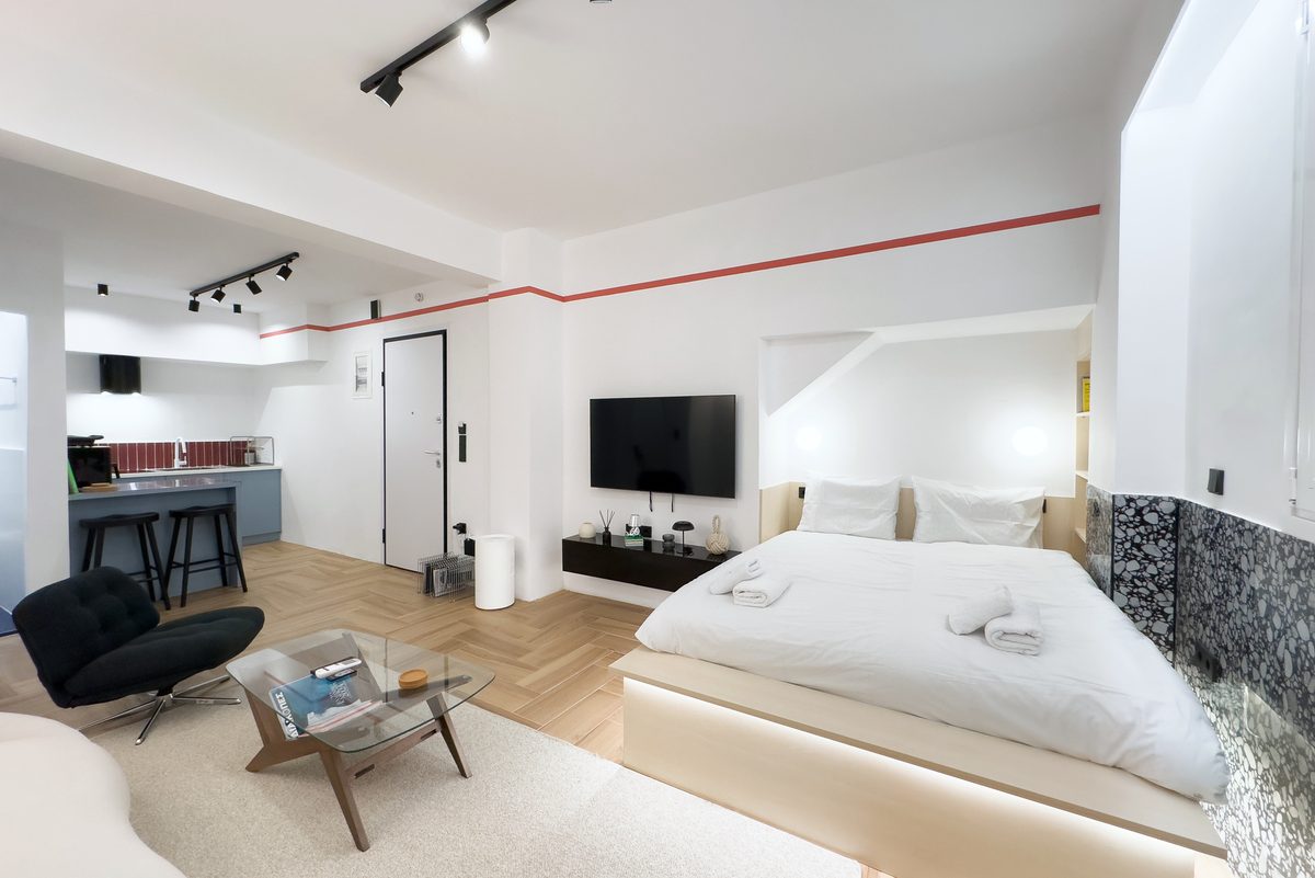Open-plan studio with platform bed and a view to the kitchen